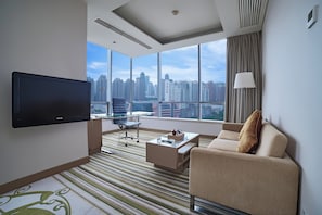 A modern hotel room with a large window offering a city view, a flat-screen TV, a sofa, a coffee table, and a lamp. - Holiday Inn Tianjin Riverside by IHG (Tianjin)