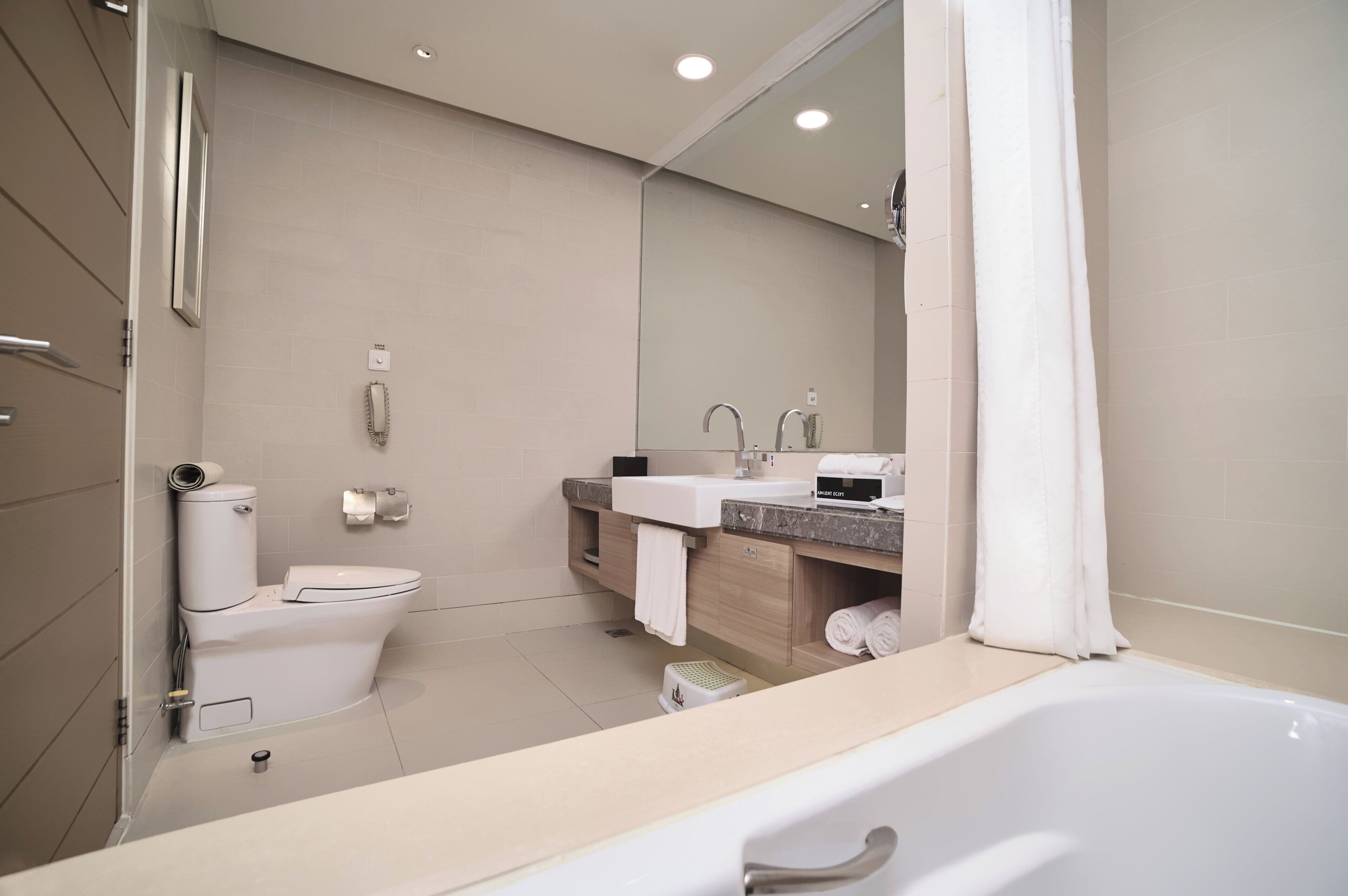 A modern bathroom with a toilet, sink, and bathtub.