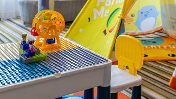A LEGO play area with a Ferris wheel, a table, and a yellow play mat.
