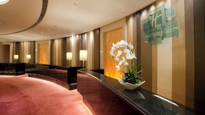 A hotel reception area with a curved reception desk, a red carpet, and a wall-mounted sign. - Holiday Inn Tianjin Riverside by IHG (Tianjin)
