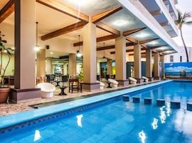 Una piscina al aire libre, sillones reclinables de piscina