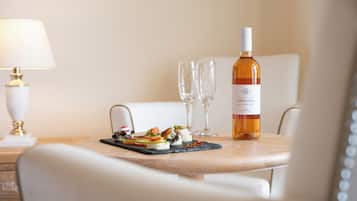 A table with a bottle of wine, two glasses, and a small appetizer plate.