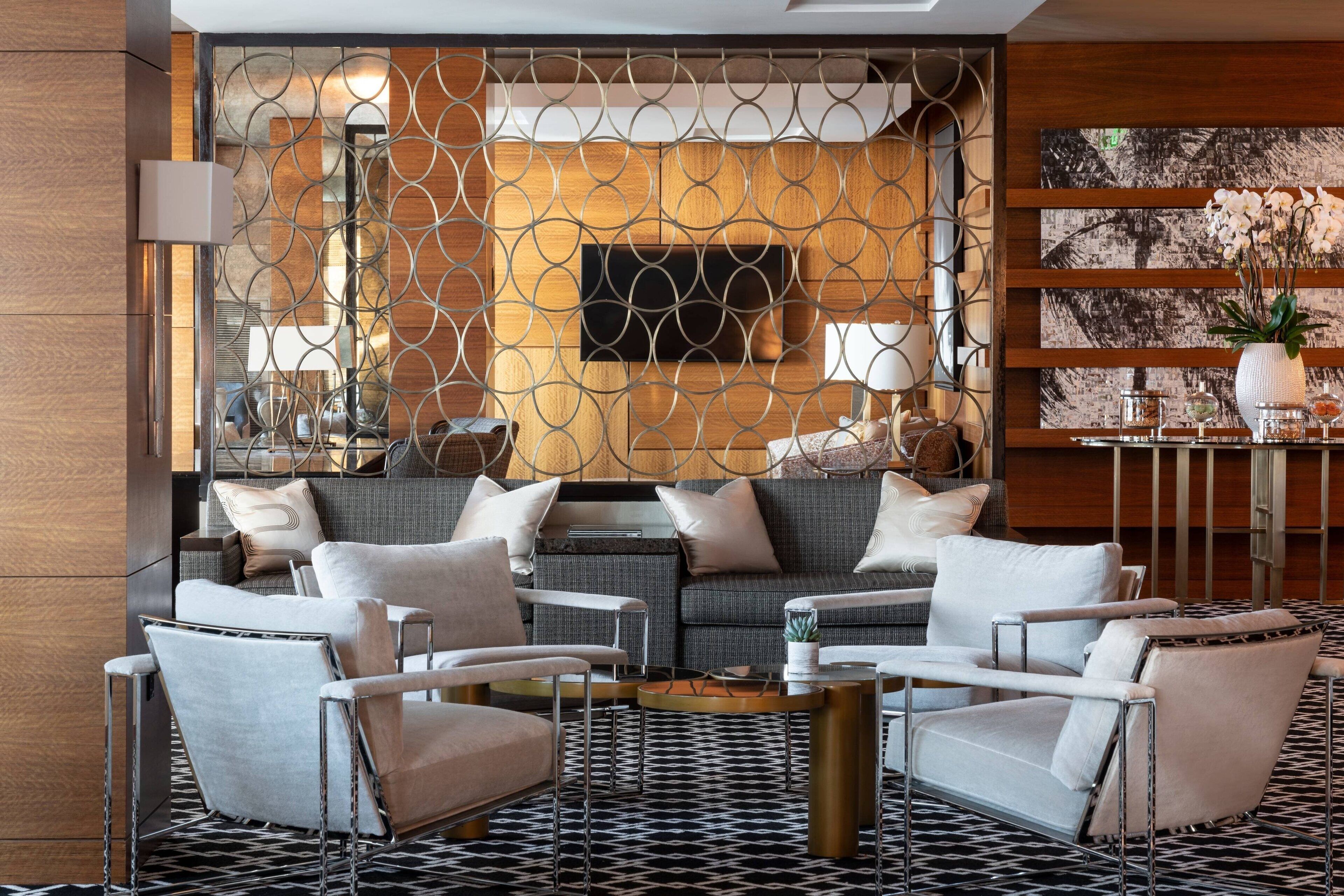 A modern living room with a sofa, armchairs, and a coffee table.