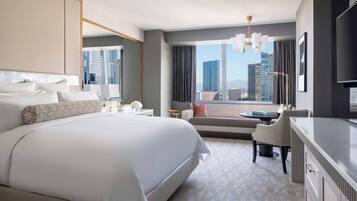 Une chambre d’hôtel moderne, dotée d’un grand lit, d’un bureau, d’une chaise et offrant une vue sur le paysage urbain.