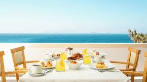 A table set with breakfast items and a view of the ocean. - Canvas by Mitsis Family Village (Kos)
