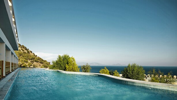 A swimming pool with a view of the sea and a hillside. - Canvas by Mitsis Family Village (Kos)