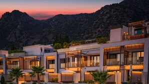 Un complexe hôtelier moderne doté de nombreuses chambres, d’espaces de détente en plein air et offrant une vue sur les montagnes.