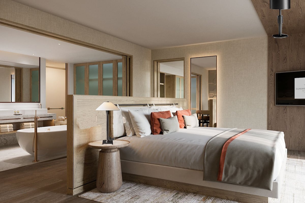 Un dormitorio moderno con una cama grande, una mesita de noche, una lámpara, un espejo y un televisor.