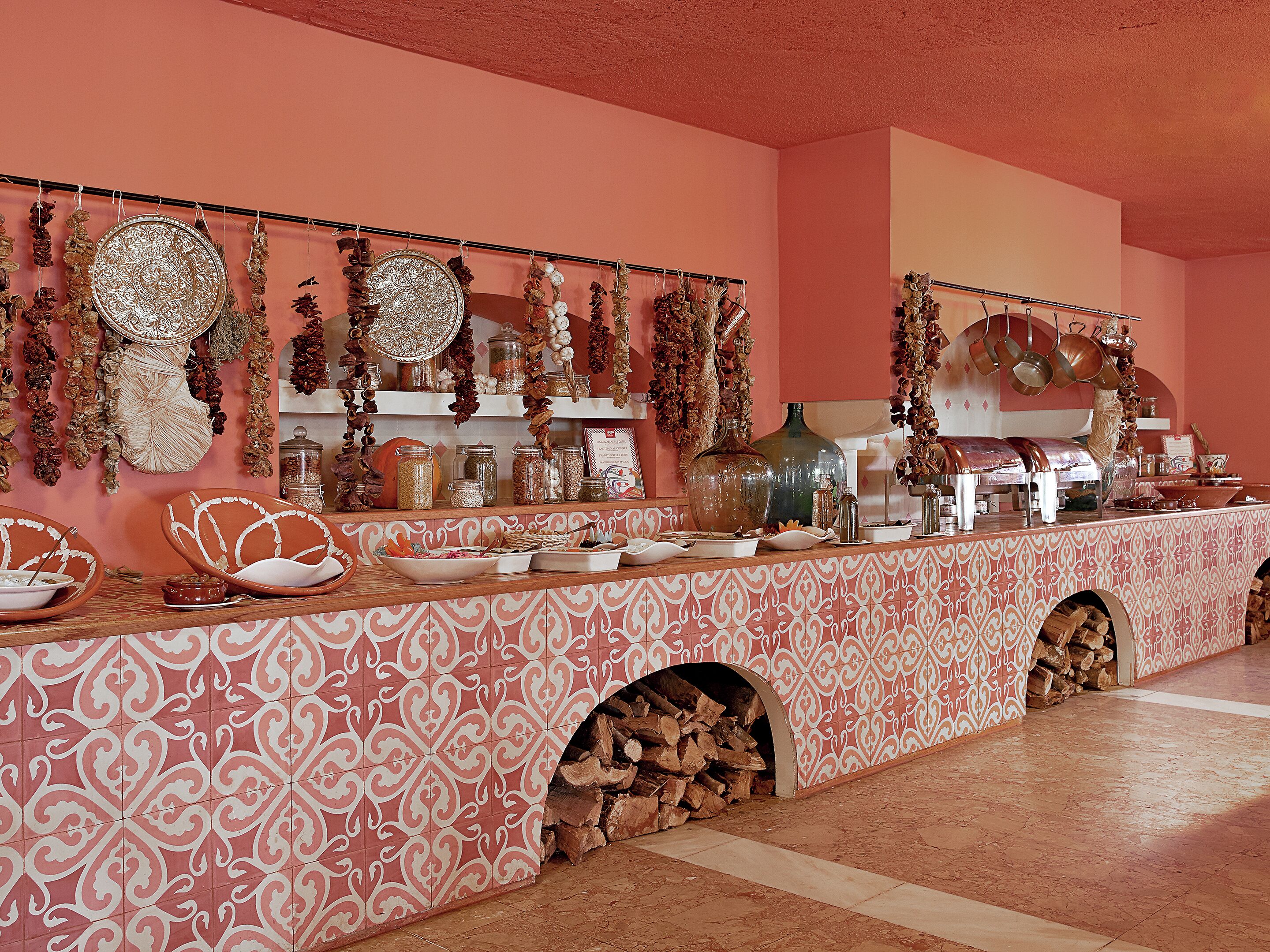 A kitchen with a patterned backsplash, hanging decorations, and a variety of kitchenware.