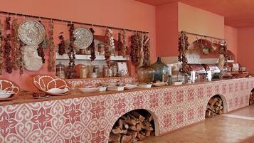 A kitchen with a patterned backsplash, hanging decorations, and a variety of kitchenware.