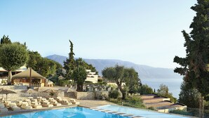 Zona piscina con lettini e vista sul mare.