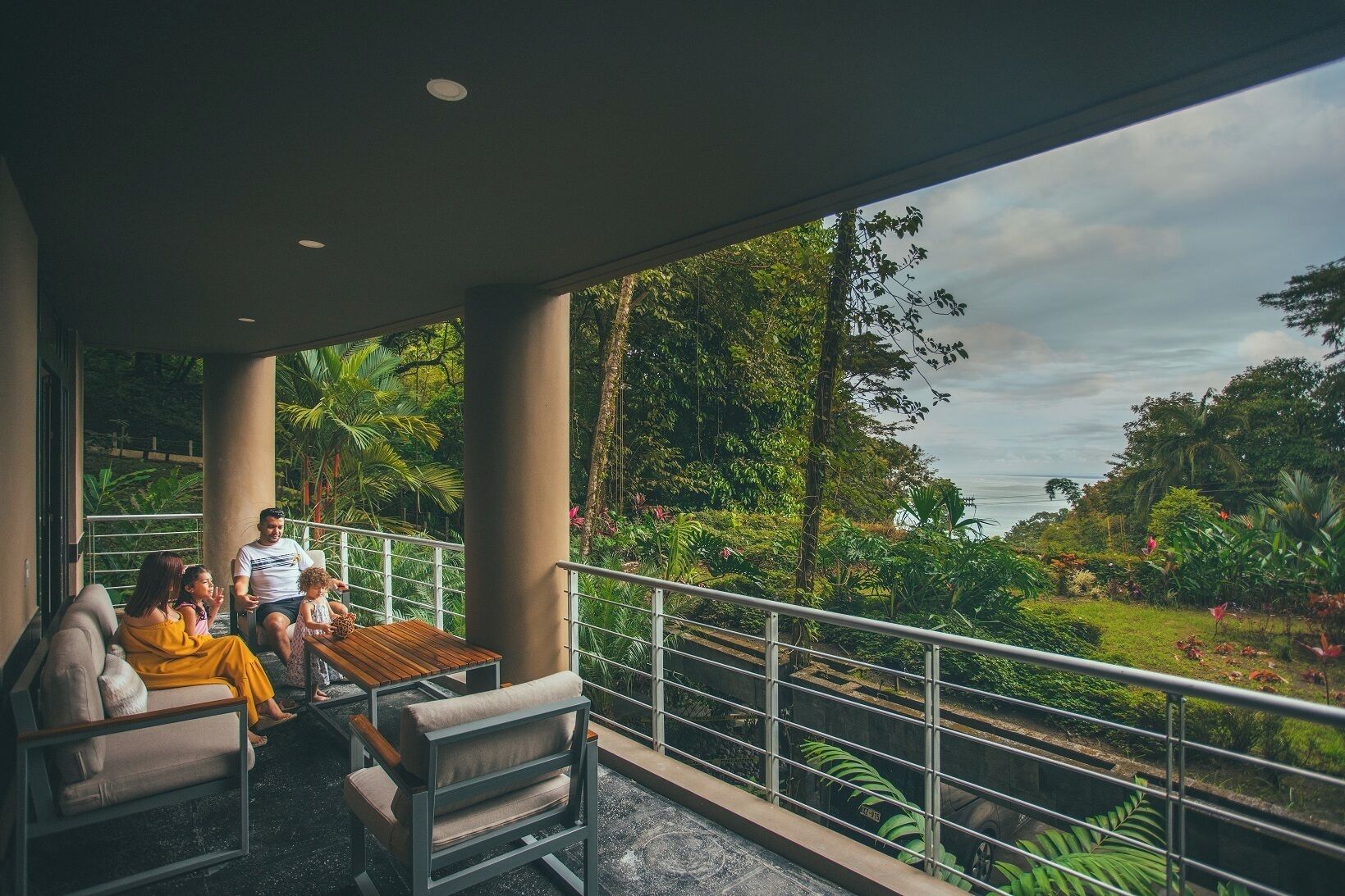 A balcony with a view of lush greenery and a body of water.