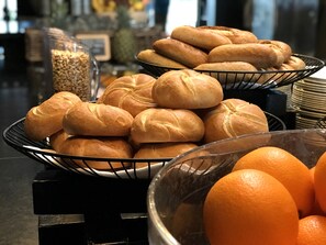 Un bufé con pan y naranjas.