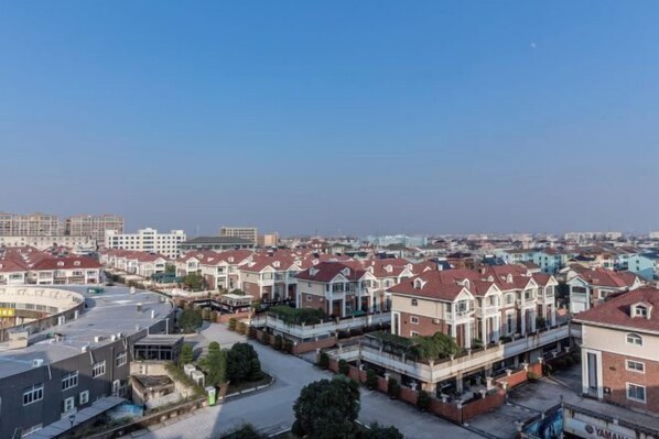 A residential area with multiple townhouses, a clear sky, and a distant cityscape.