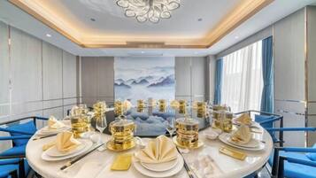 Una mesa redonda con sillas dispuestas para una comida, en una habitación de diseño moderno y con un ventanal grande.