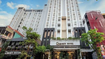 Un hotel con una entrada llamativa, varios pisos y una fachada moderna.