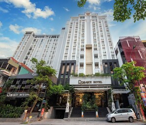 A hotel with a prominent entrance, multiple floors, and a modern facade. - Romance Hotel (Hue)