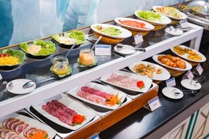 A buffet with various food options including salads, meats, and other dishes. - Romance Hotel (Hue)
