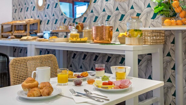 A breakfast buffet with various food items and a coffee cup on a table. - Novotel Suites Perpignan Mediterranée (Perpignan)