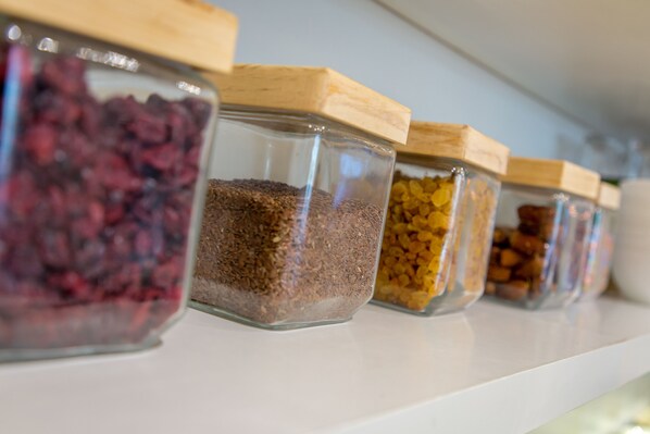 A row of glass jars with wooden lids on a shelf.