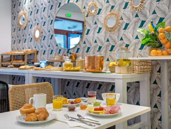 A breakfast buffet with various food items and a coffee cup on a table.