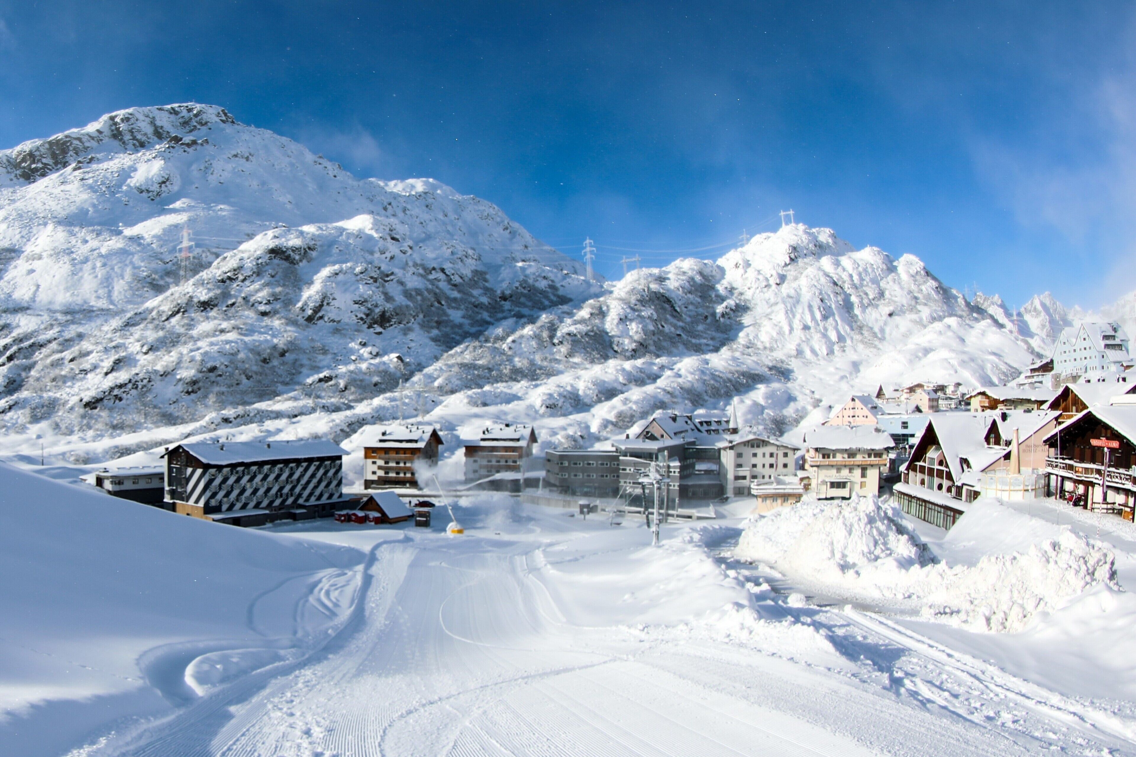 A snow-covered mountain with a ski resort, including buildings and ski lifts.