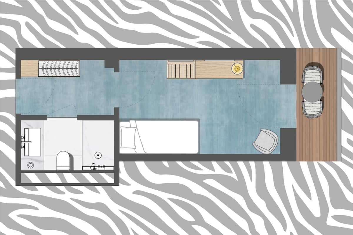 Un plan d’étage d’une chambre d’hôtel comprenant une salle de bain, un coin salon avec une table et des chaises, et une petite kitchenette.