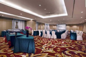 A conference room with tables set for a meeting, a projection screen, and a carpeted floor. - Grand City Hall Hotel Serviced Residences Medan (Medan)