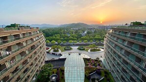 A modern building complex with multiple floors, a central courtyard, and surrounding greenery.