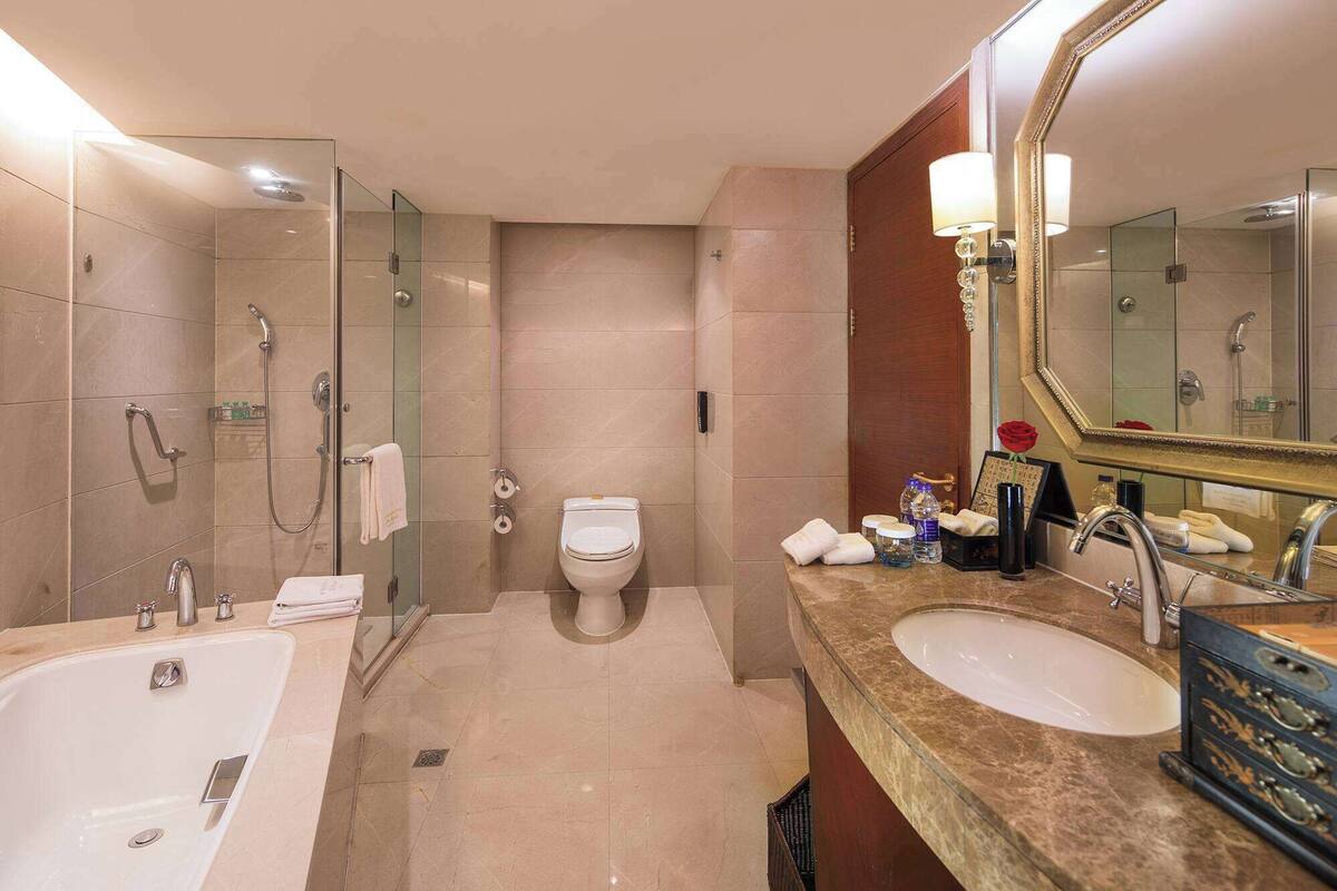 A modern bathroom with a bathtub, a sink, a toilet, and a shower area.