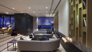 A modern living room with a sectional sofa, a coffee table, and a bookshelf. - Hotel Ilonn (Poznan)