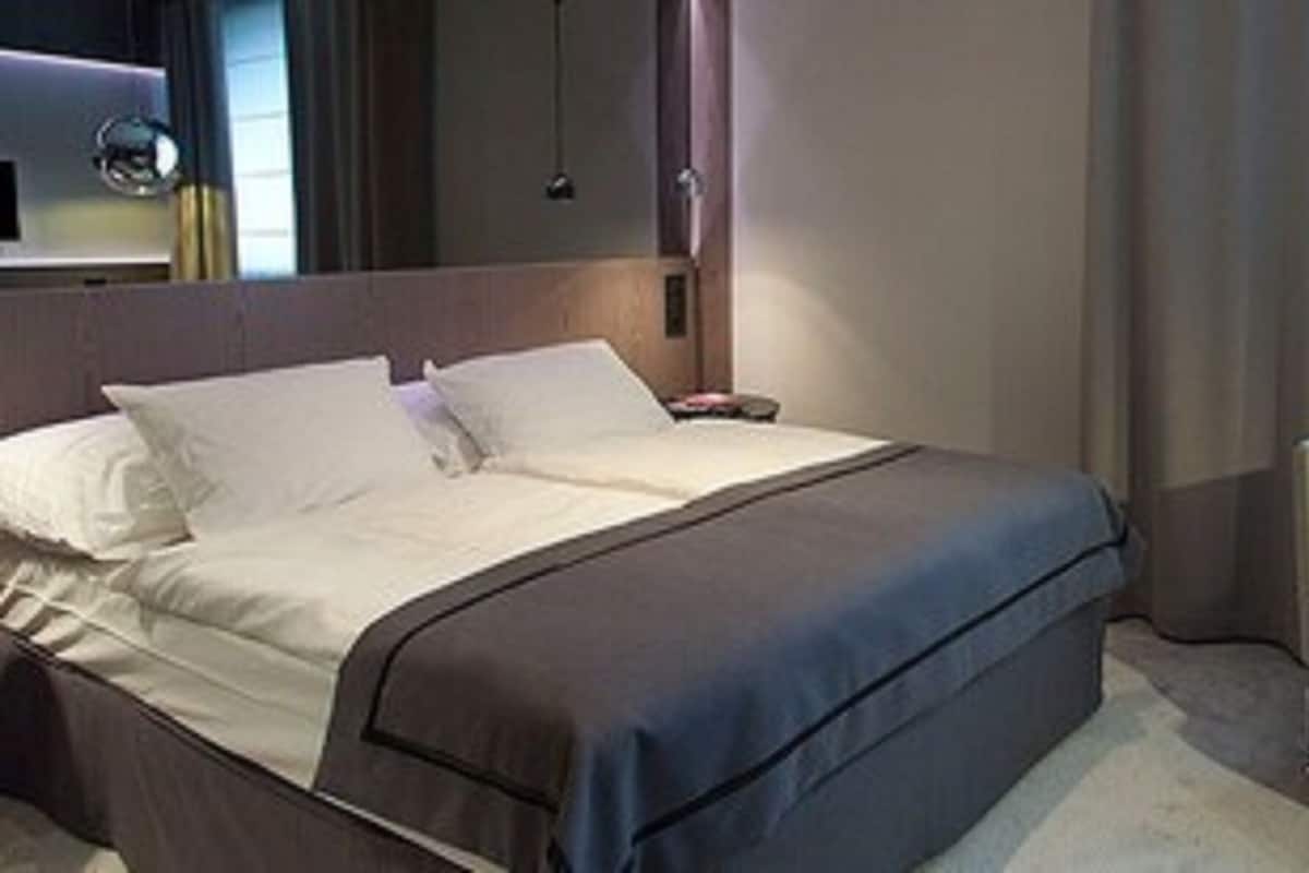 A hotel room with a bed, a chair, and a desk.
