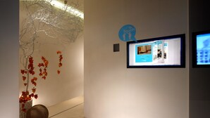 A hallway with a digital display, a decorative wall installation, and a textured sculpture. - Just Sleep Taipei Linsen (Taipei)