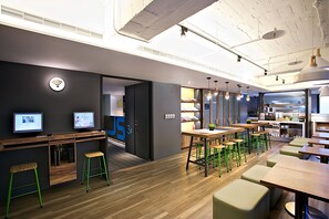 A modern office space with desks, chairs, and a kitchenette area. - Just Sleep Taipei Linsen (Taipei)