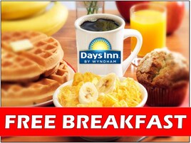Desayuno con waffles, un muffin, un bol de fruta, una taza de café y un vaso de jugo de naranja, con un cartel que ofrece desayuno gratuito.