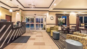 A hotel lobby with a reception desk, seating area, and a view of the pool. - Days Inn & Suites by Wyndham Mineral Wells (Mineral Wells)