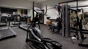 Une salle de sport équipée de tapis de course, de vélos elliptiques et de matériel de musculation.