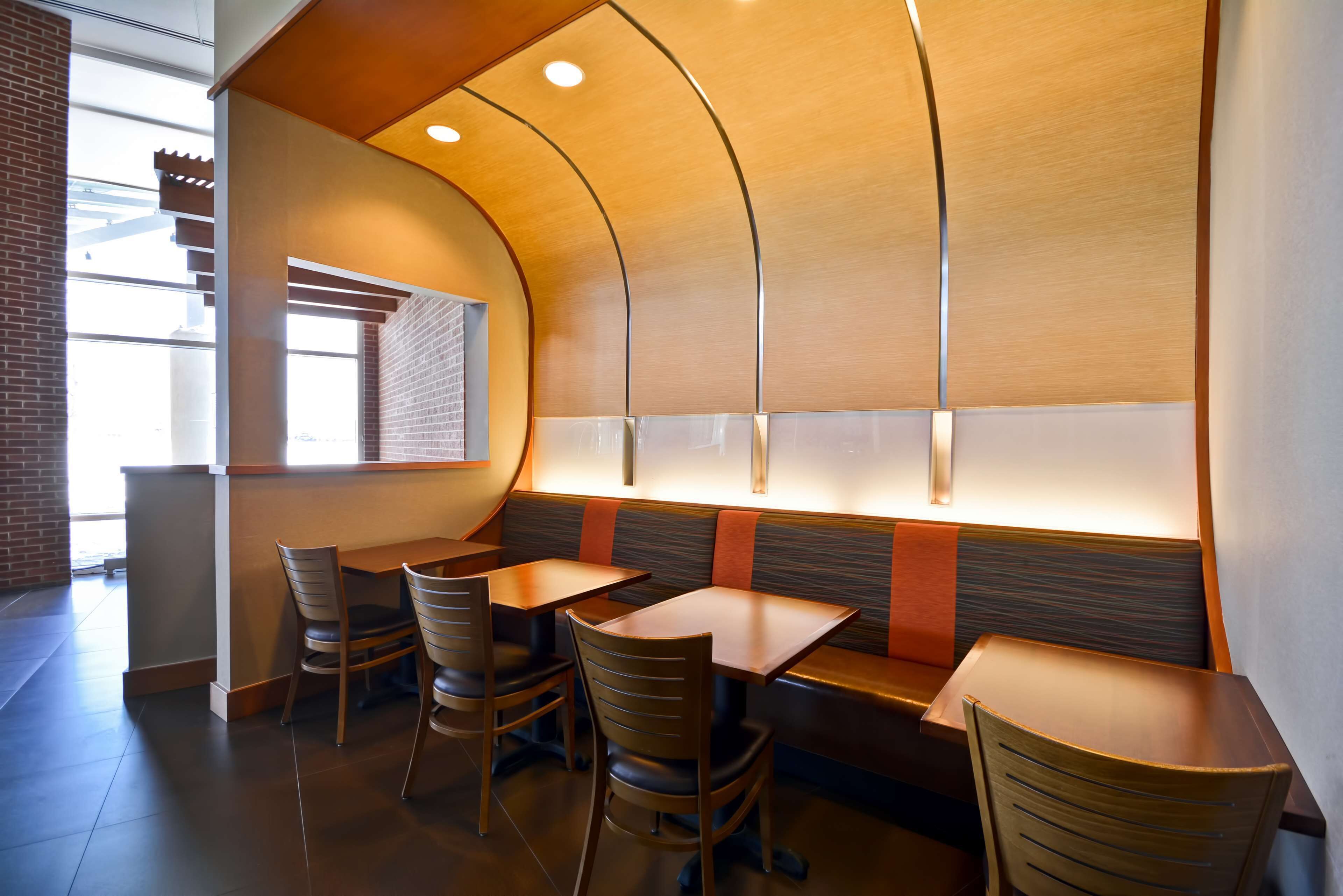Un ristorante con sedute a cabina, tavoli e sedie in legno.