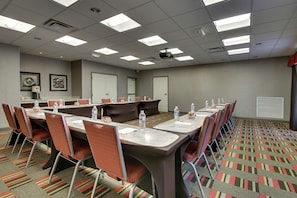 Conference room with a long table, six chairs, and a projector for presentations.