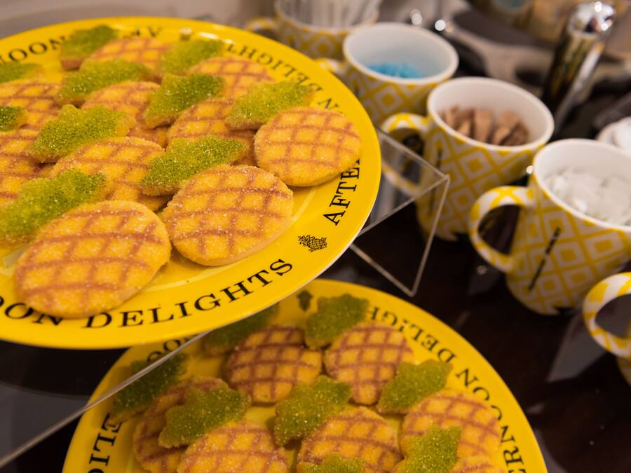 A table with plates of waffles and green sugar decorations, surrounded by patterned cups and bowls.