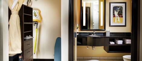 A modern bathroom with a wooden vanity, a large mirror, and a framed artwork on the wall.