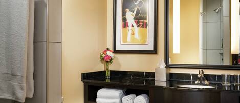 A modern bathroom with a toilet, a vanity with a mirror, and a towel rack.