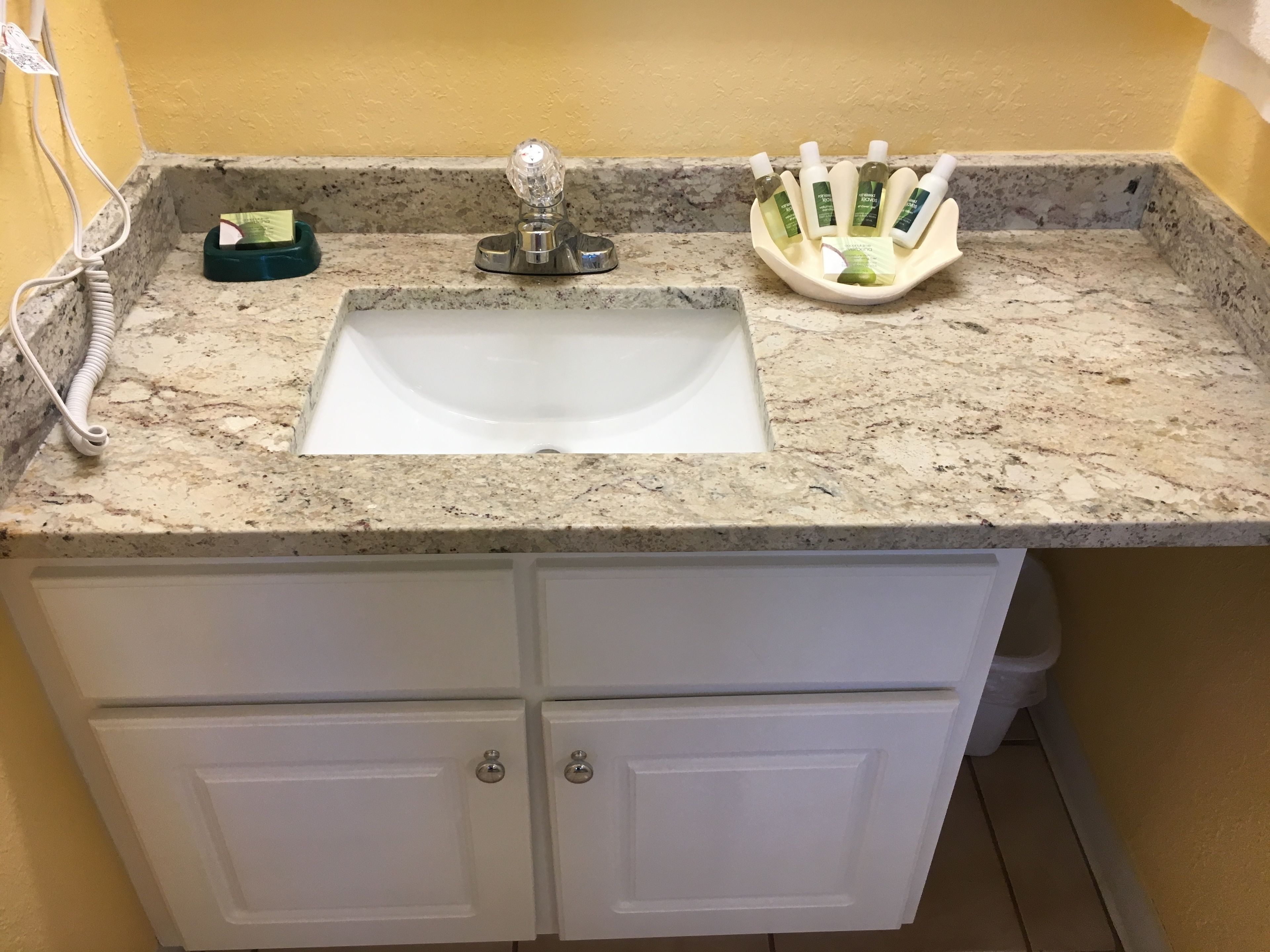 A bathroom with a sink, countertop, and storage cabinets.