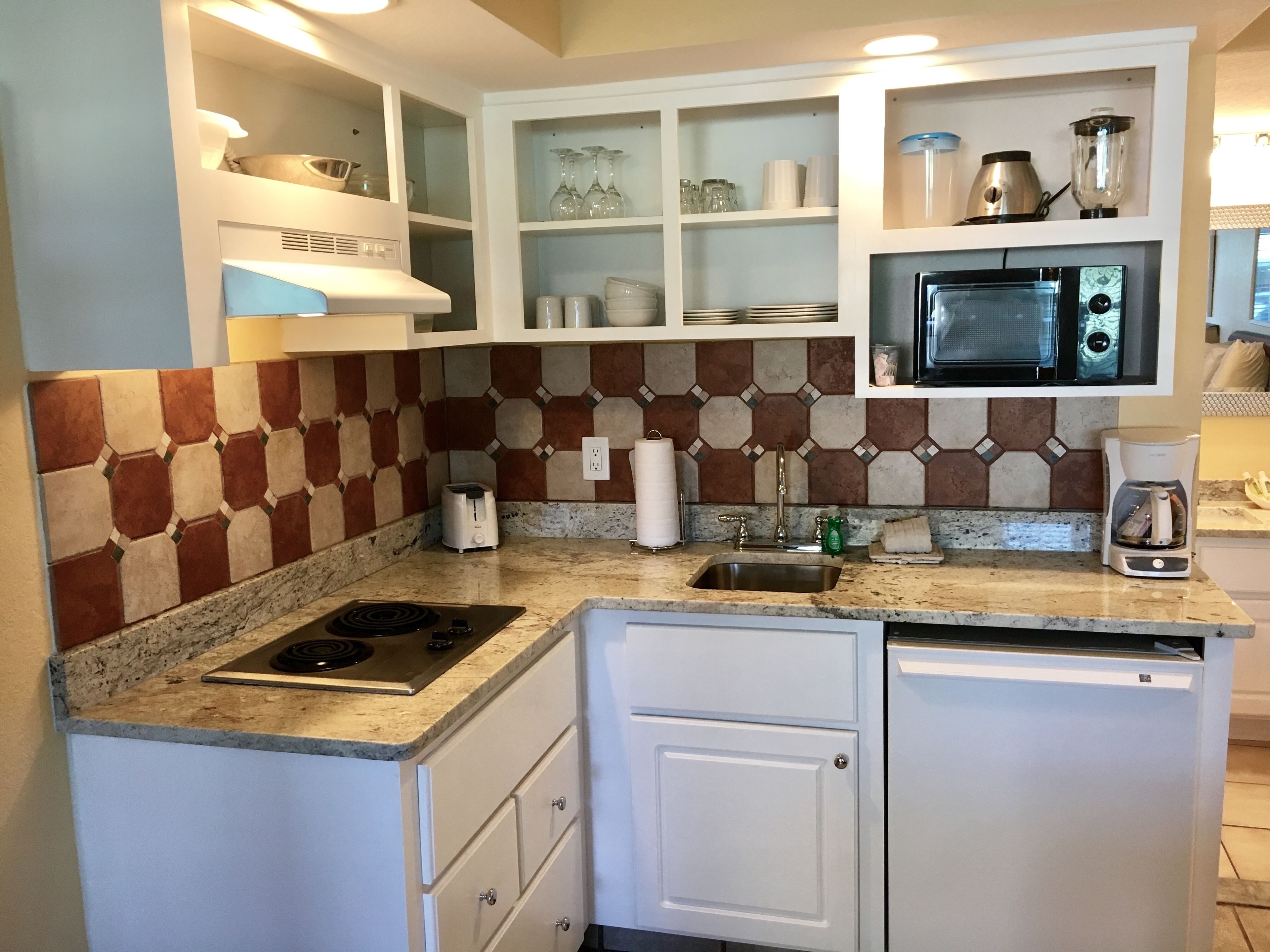 A compact kitchen with a microwave, toaster, and coffee maker.