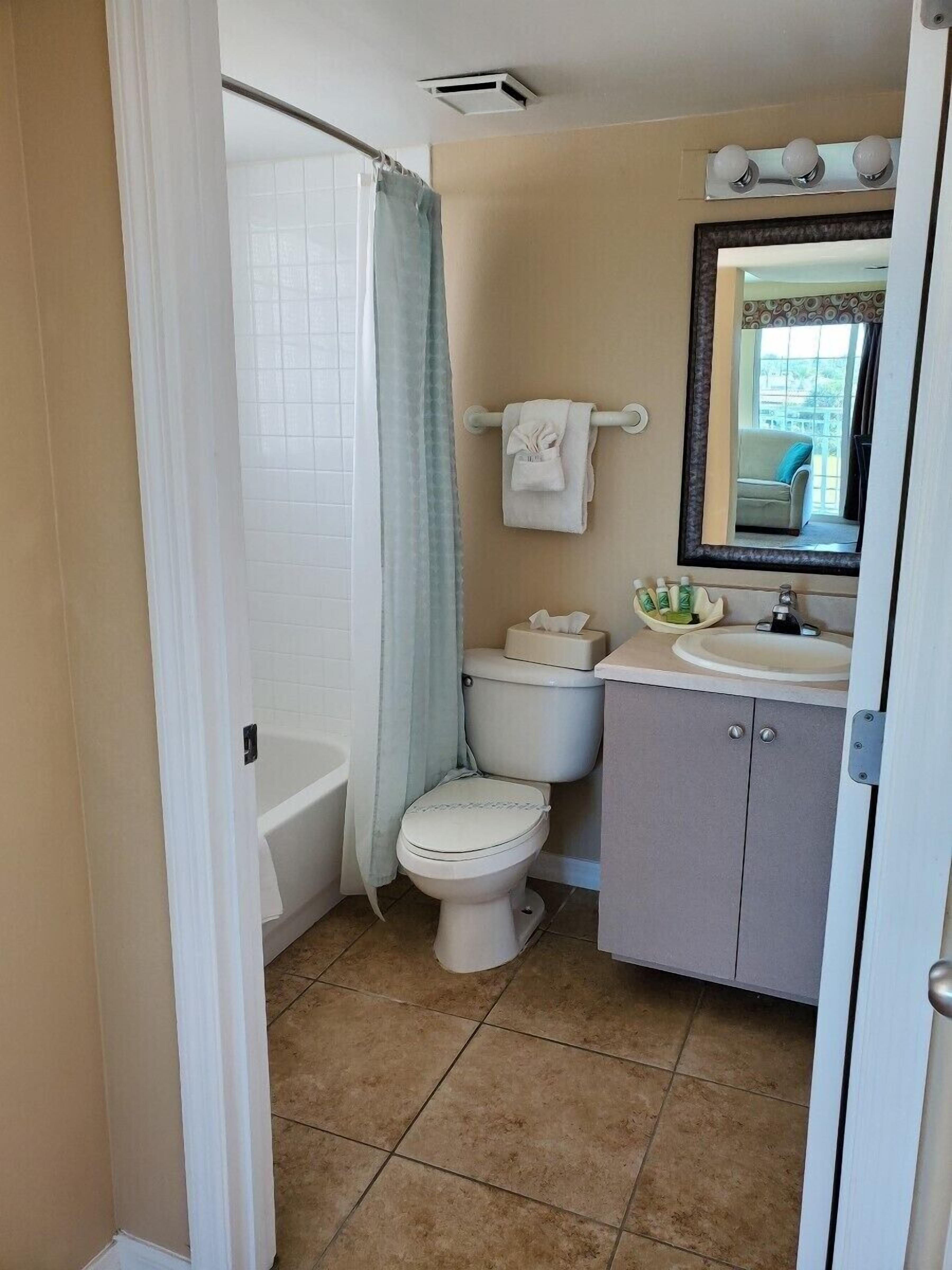 A bathroom with a bathtub, toilet, and sink.