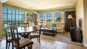Amplia sala de estar con comedor, ventanas grandes y vistas al exterior.