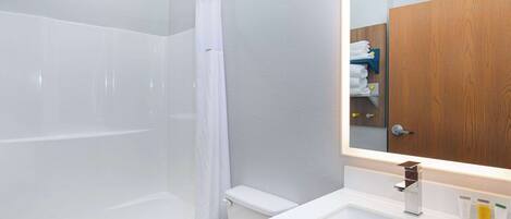 A modern bathroom with a shower, toilet, and sink.