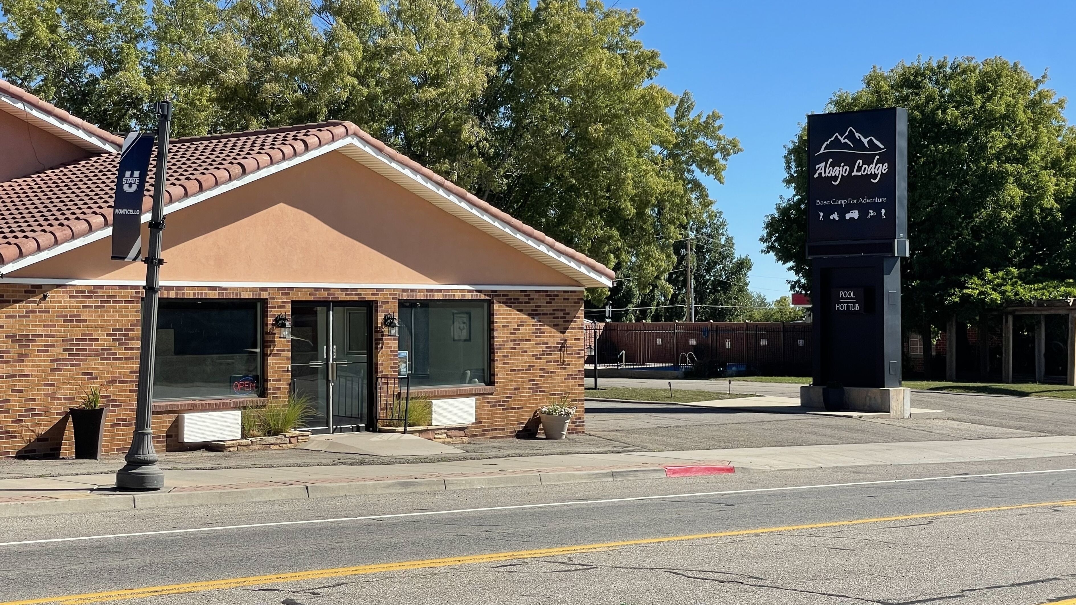 A brick building with a sign for 'Abajo Lodge' indicating it is a base camp for adventure.