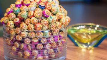 A clear glass container filled with colorful wrapped candies.