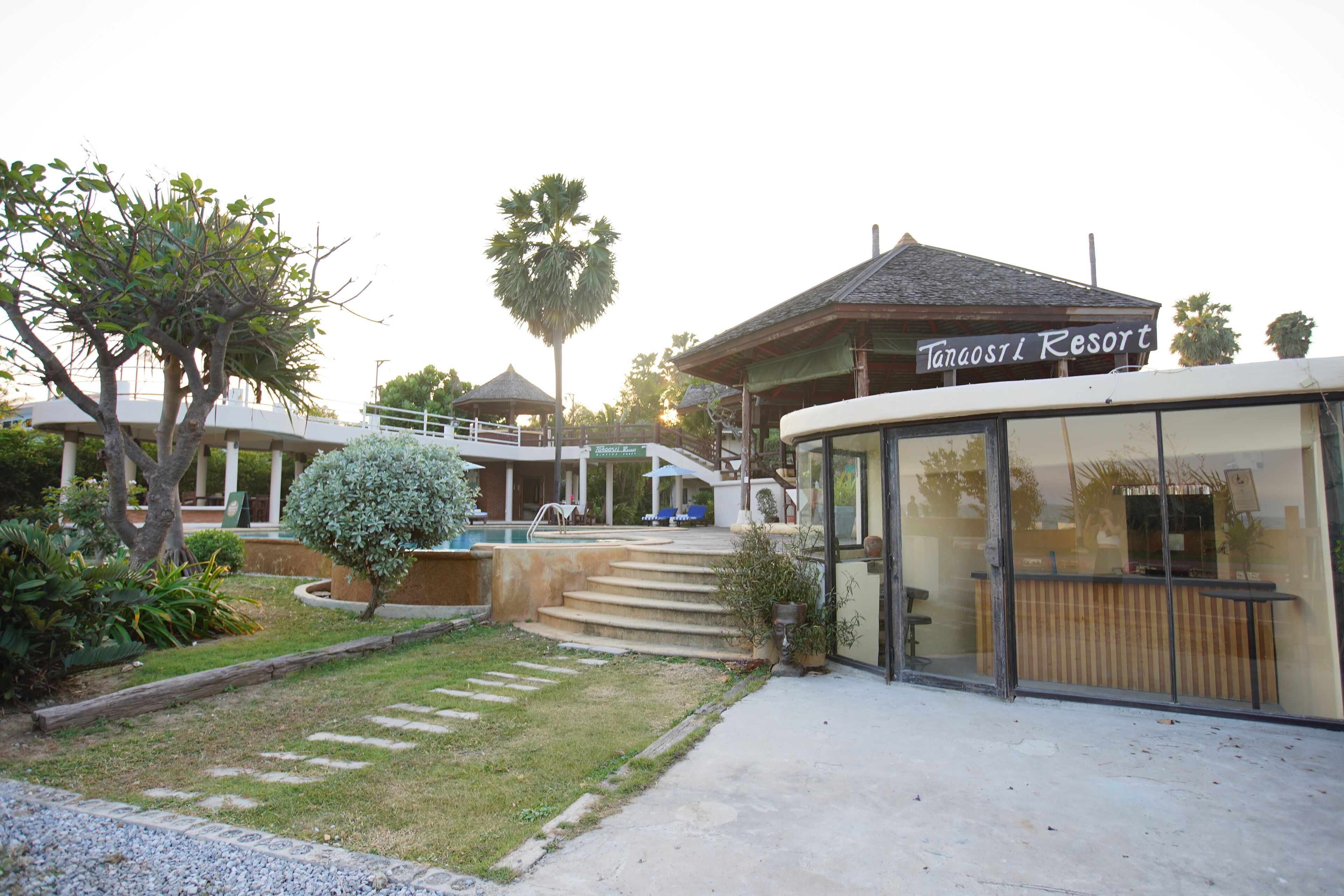 A resort with a pool, outdoor seating, and a building labeled "Tanaost L Resort".